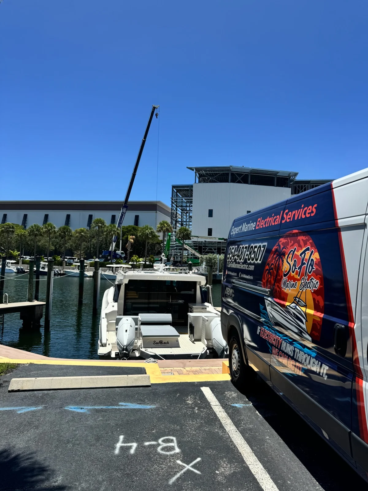 SoFlo Marine Electric's branded service van beside a boat docked at the marina